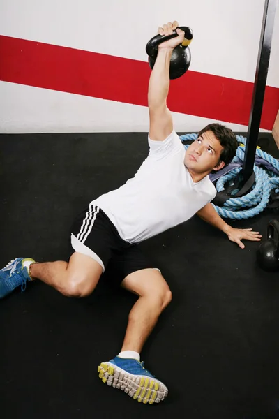 Jovem fazendo kettlebell treino no ginásio — Fotografia de Stock