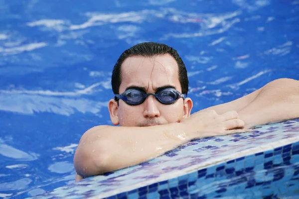 Мужчина-пловец отдыхает после нескольких кругов в закрытом бассейне — стоковое фото