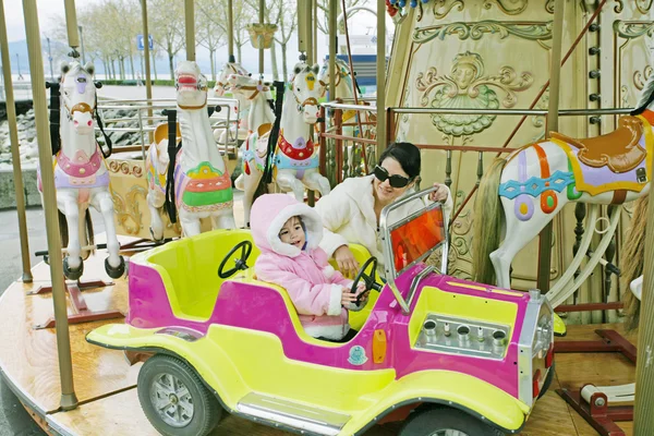 Vrouw met kindje op carrousel — Stockfoto