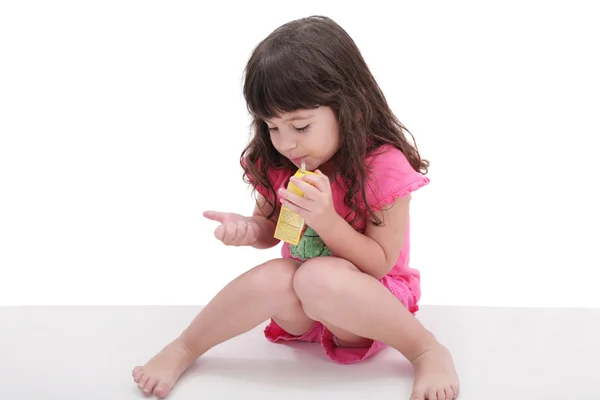 Close-up of beautiful little girl drinking from a juice box. Sho — Stock Photo, Image