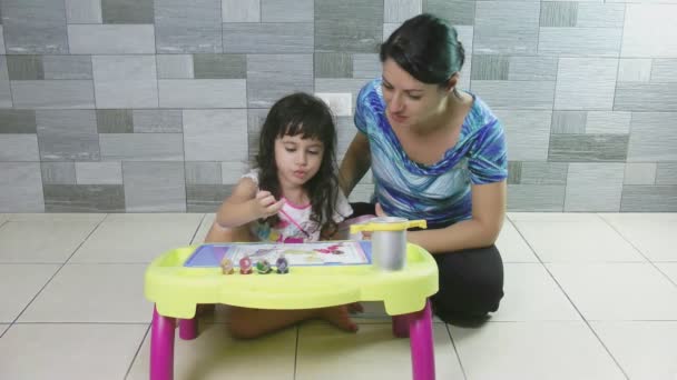 Mother teaching her little daughter to paint. — Stock Video