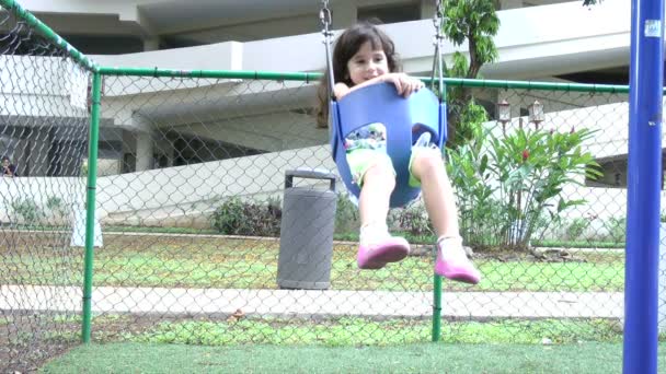 Movimento lento, uma menina balança num baloiço — Vídeo de Stock