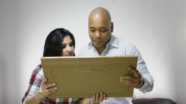 Casal instalando uma moldura juntos em sua nova casa — Vídeo de Stock