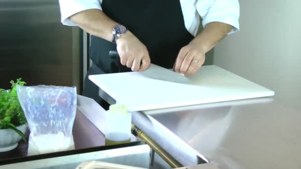 Vista recortada de las manos de un hombre cortando un hongo con un cuchillo de cocina en una tabla de cortar — Vídeo de stock