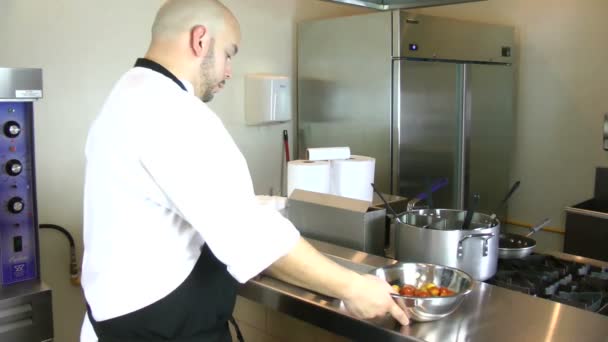 Cocinero poniendo bandeja para hornear con tomates en el horno — Vídeo de stock