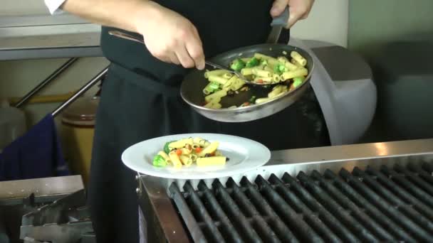 Шеф-повар, подающий ригатони на кухне — стоковое видео