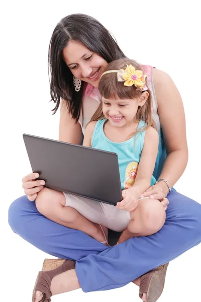 年轻的母亲和女儿看着笔记本电脑。在妈妈的焦点 — 图库照片