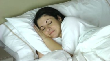 evde yatağında uyuyan kadın çok mutlu bir rüya