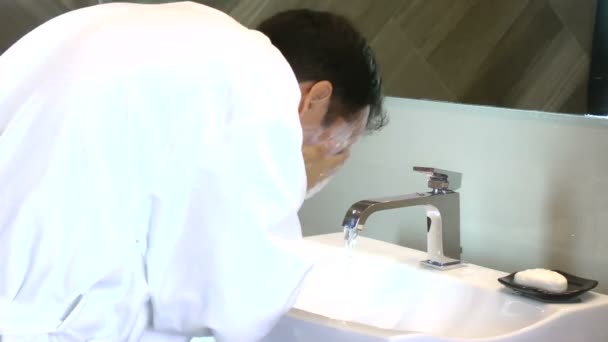 Молодий чоловік миє обличчя в раковині — стокове відео