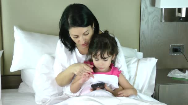 Mutter bringt ihrer kleinen Tochter das Spielen im Handy bei — Stockvideo