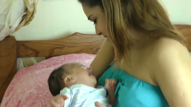 Mother consoling a crying newborn baby in her bedroom — Stock Video