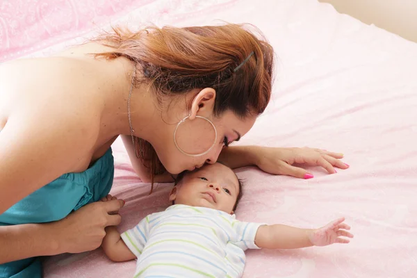 年轻的母亲亲吻她小的新生儿 — 图库照片