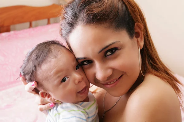 Retrato de una joven madre hispana feliz sosteniendo un bebé — Foto de Stock