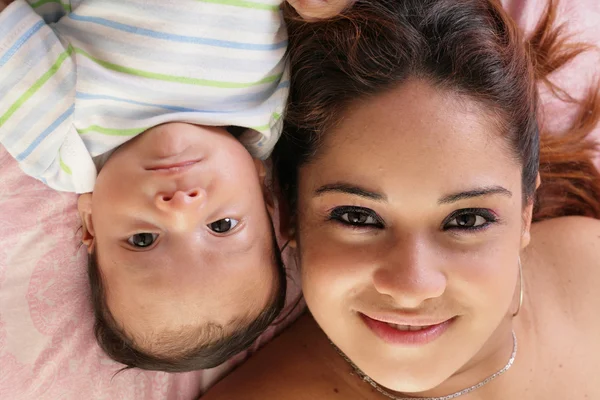 Retrato de una hermosa madre hispana feliz con el bebé mintiendo hacer —  Fotos de Stock