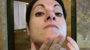 kadın banyoda yüzünü denetleme