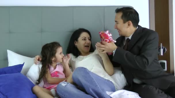 Esposo dando un regalo a su esposa con hija en el dormitorio — Vídeos de Stock