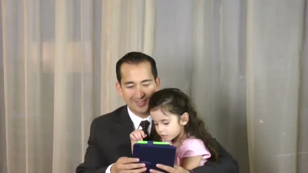 Man with daughter playing with digital tablet — Stock Video