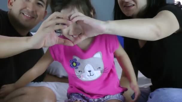 Cara de niña en las manos de madre y padre, en forma de corazón. El símbolo del cuidado, la educación y el amor familiar — Vídeo de stock