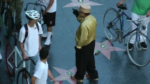 HOLLYWOOD, California - CIRCA 2014: tourists gather around a street performer in Hollywood at sunset on CIRCA 2014 in Hollywood. — Stock Video