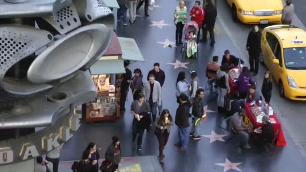 LOS ANGELES - CIRCA 2014: Turistas caminhando nas estrelas da Calçada da Fama de Hollywood no CIRCA 2014 em Los Angeles, Califórnia. Hollywood Walk of Fame é uma atração turística principal em Los Angeles . — Vídeo de Stock