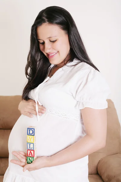 Close up of a pregnant woman with baby letters on her hand — Stock Photo, Image