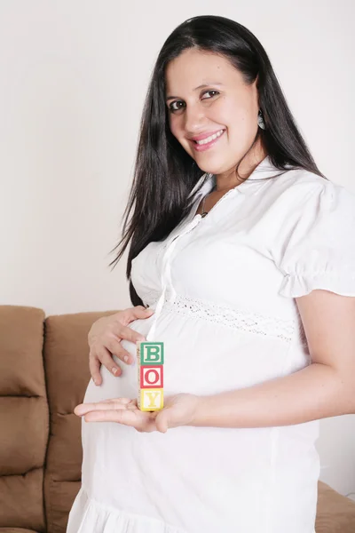 Schöne hispanische schwangere Frau mit dem Wort Junge mit Holz — Stockfoto