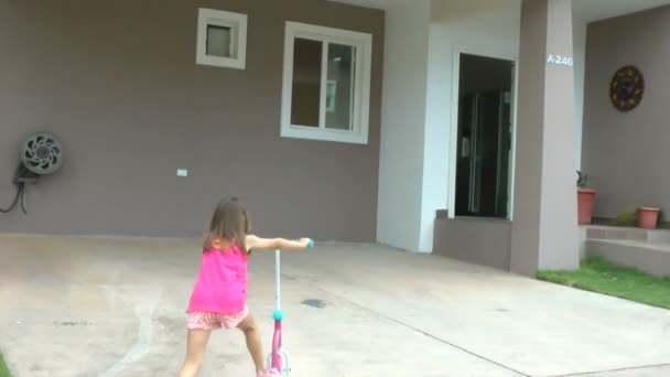 Niña dejando caer su scooter en frente de su casa y entrar en el interior — Vídeo de stock