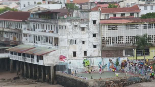 Pessoas que jogam futebol fora de casas de lata — Vídeo de Stock