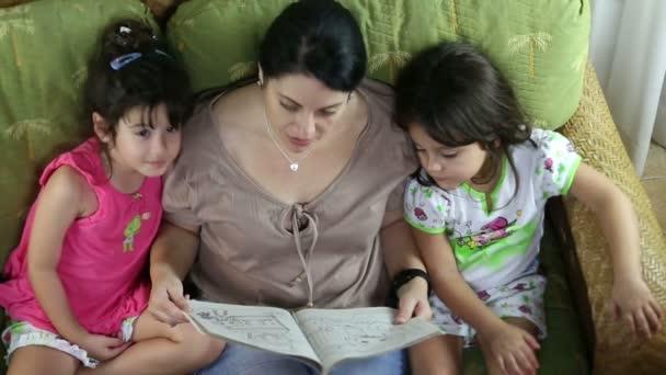 Visão superior de uma família feliz lendo um livro — Vídeo de Stock