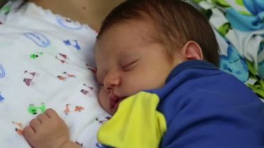 Annenin kollarında uyuyan bebek