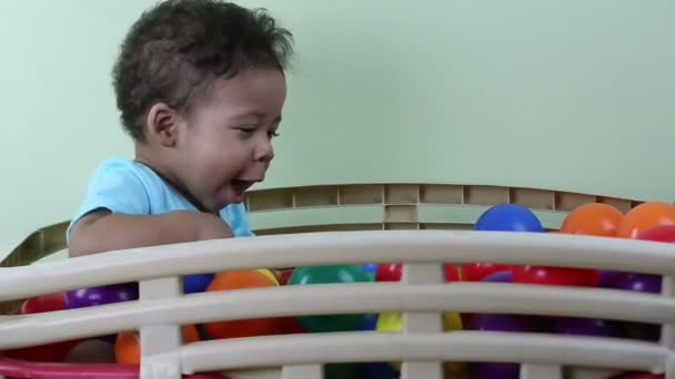 Dziecko bawiąc się kolorowe kulki — Wideo stockowe