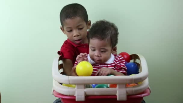 Брати грають з різнокольоровими кульками — стокове відео