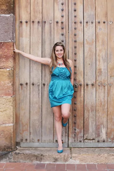 Bella donna nel vestito in vecchia porta di legno — Foto Stock