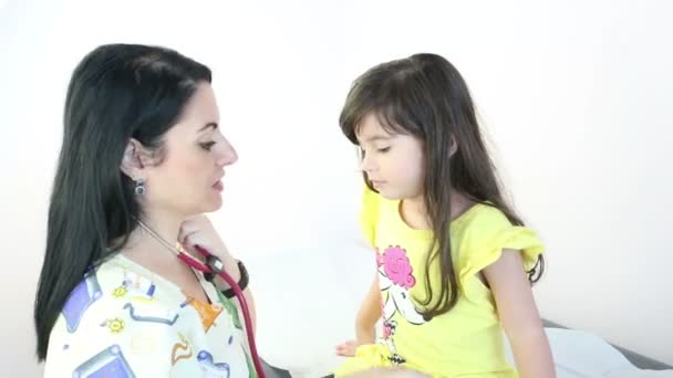 Doctor teaching the use of the stethoscope to a girl — Stock Video