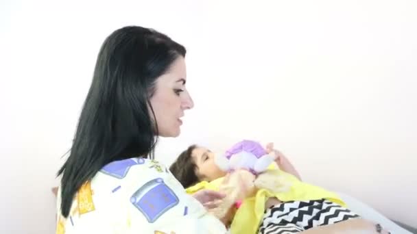 Красивый терапевт готовит маленькую девочку для массажа — стоковое видео