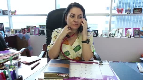 Женщина-врач с повесткой дня и мобильным телефоном — стоковое видео