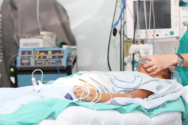 Unidentified patient receiving oxygen by a breathing mask holded — Stock Photo, Image