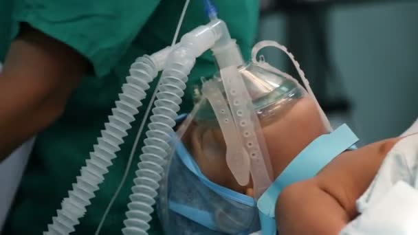 Bambino non identificato con una maschera di ossigeno su un intervento chirurgico critico — Video Stock