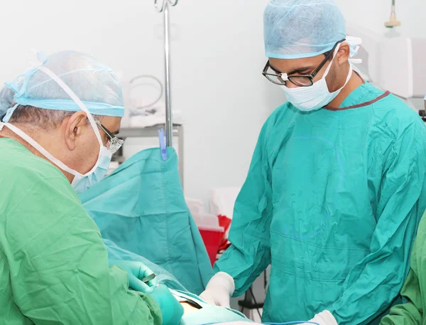 Cirurgiões que trabalham na sala de operação — Fotografia de Stock