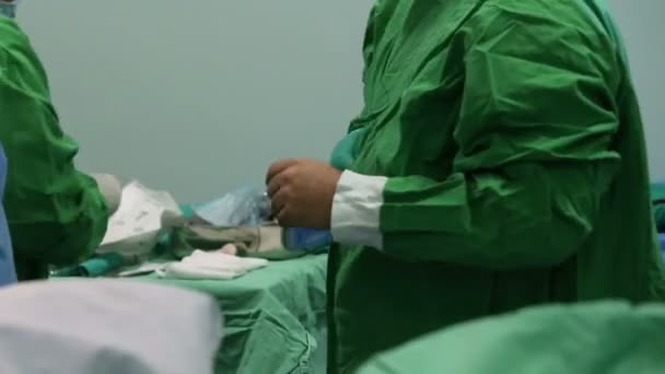 Assistent legt dem Chirurgen Handschuhe an, um Kontamination zu vermeiden