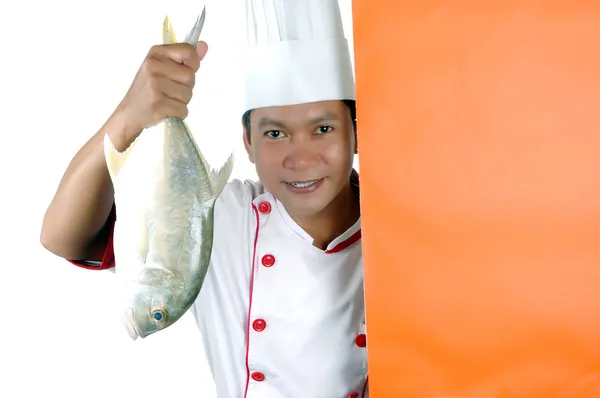 Chef tenant un gros poisson cru avec espace vide orange — Photo