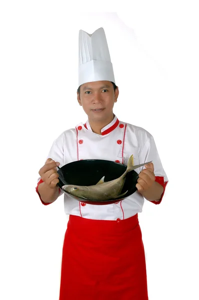 Chef sosteniendo pescado crudo en una sartén — Foto de Stock