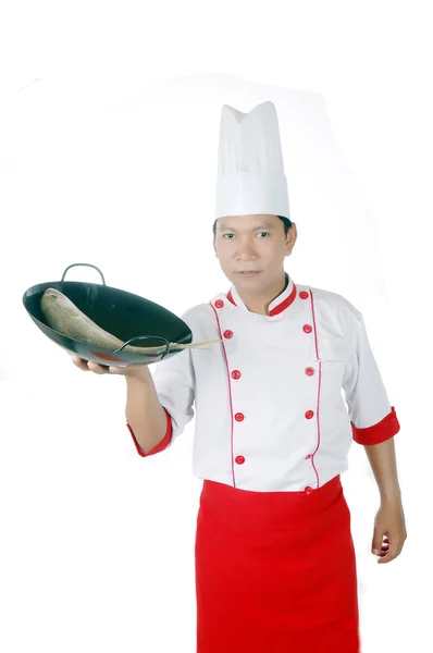 Chef sosteniendo pescado crudo en una sartén negra —  Fotos de Stock