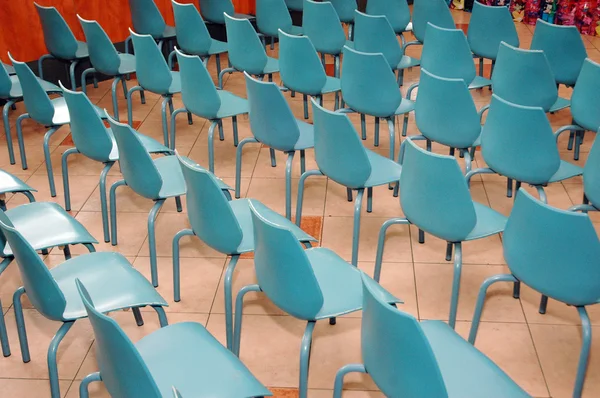 Arrangement of rows of small blue chairs — Stock Photo, Image