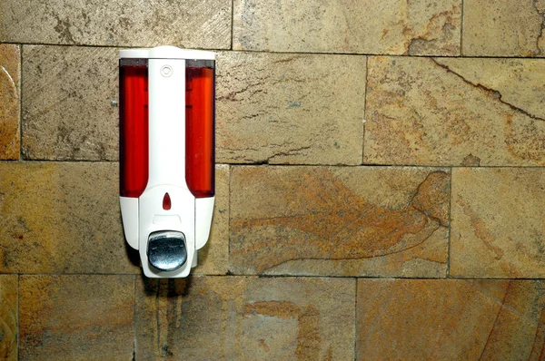 Liquid soap container attached to the brick wall — Stock Photo, Image