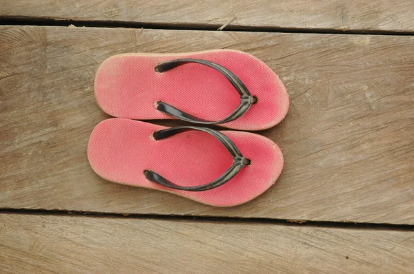 Chanclas rojas usadas en tablero de madera — Foto de Stock