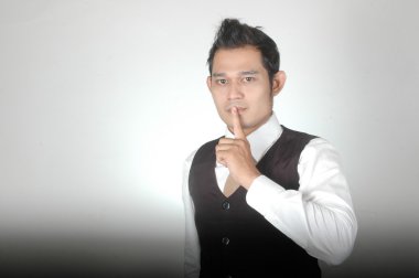 Asyalı genç adam hareketlerle sessizlik için işaret etti.