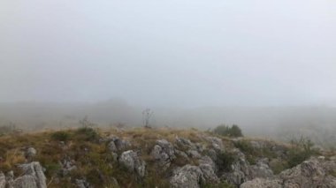 Dağda yağmur yağıyor, kayalıklarda dururken