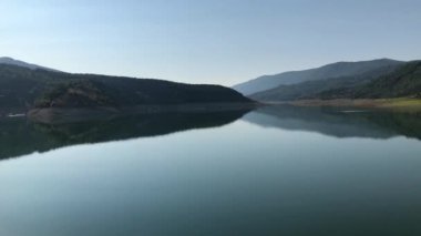 Güneşli bir yaz gününde sabahın erken saatlerinde sakin bir göl manzarası