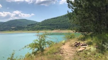 Güneşli bir yaz gününde göl kenarında yürüyorum.